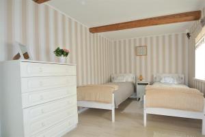 a bedroom with two twin beds and a dresser at Koidula Pesa in Haapsalu