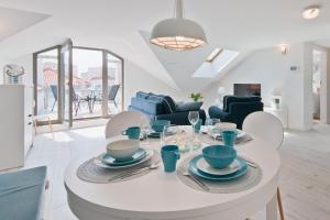 Apartamenty Gdańsk EU - Waterlane في غدانسك: غرفة معيشة مع طاولة وكراسي بيضاء