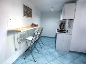 a kitchen with white cabinets and a counter and chairs at B&B La Grotta Marina in Vico Equense