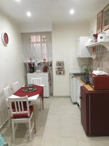 シラクーサにあるIl Vinile Apartmentのキッチン(テーブル、赤いテーブル、椅子付)