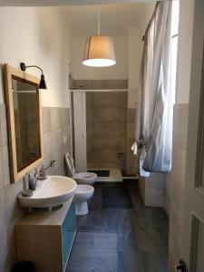 a bathroom with two toilets and a sink and a mirror at B&B Al Fronte del Porto in Genova