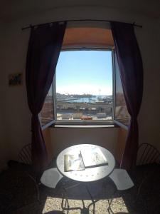 uma mesa em frente a uma grande janela com vista em B&B Al Fronte del Porto em Génova