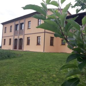 an old house with a green lawn in front of it at Il Casale Giallo in Montefalco