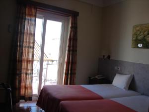 a hotel room with two beds and a window at Hotel Santa Barbara in Beja