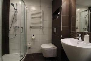 y baño con ducha, aseo y lavamanos. en Apartament Meander en Szklarska Poręba