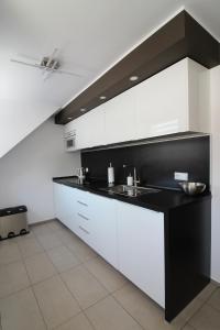 cocina con armarios blancos y encimera negra en Apartament Meander en Szklarska Poręba