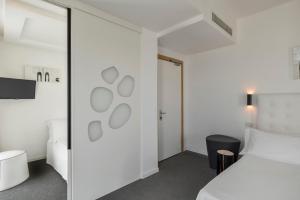 A bed or beds in a room at Hotel Fedora Riccione