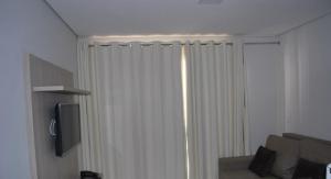 cortina blanca en una habitación con sofá en Casa da Madeira - Achei Ferias 2q, en Caldas Novas