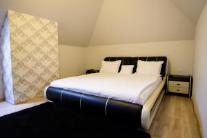 a bedroom with a bed with white sheets and a window at Cetate Residence in Braşov