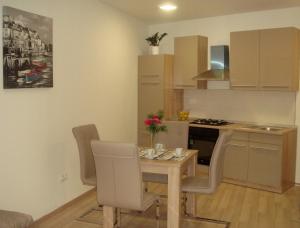a kitchen with a table and chairs in a room at Apartments Nik in Selce