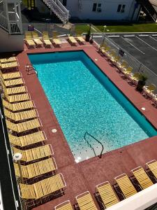 Elle offre une vue sur la grande piscine bordée de chaises. dans l'établissement Empress Motel, à Ocean City