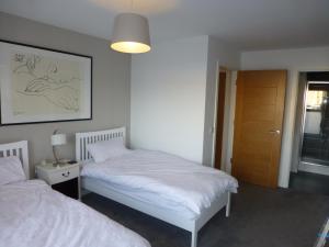a bedroom with two beds and a lamp and a door at Apartment on the beach in Edinburgh