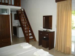a room with a bedroom with a bed and a television at Hotel Zachos in Troulos