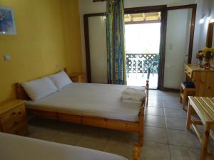 a bedroom with a bed and a large window at Hotel Zachos in Troulos