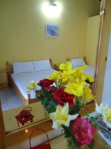 a vase of flowers on a table in a bedroom at Hotel Zachos in Troulos