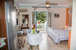 a living room with a bed and a table with flowers on it at Filoxenia Studios in Vromolithos