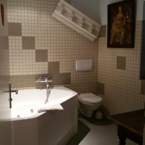 y baño con bañera, aseo y lavamanos. en Chambres touristiques La Cour Des Hôtes en Obernai
