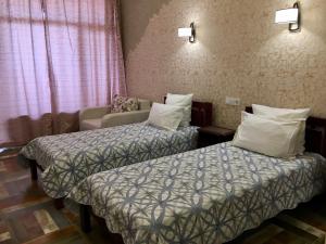 a hotel room with two beds and a couch at Sunrise in Feodosia