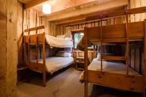 a bedroom with bunk beds in a log cabin at Huilo Huilo Apartamentos Club Huillín in Huilo Huilo
