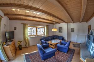 a living room with blue chairs and a television at Lauchlehen in Bischofswiesen