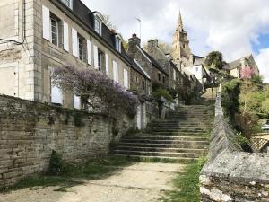 an alley in a town with purple wreaths on the buildings at Le studio Florent in Lannion