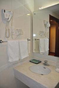 a bathroom with a sink and a mirror and towels at King Parkview Hotel in Beijing