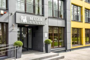 a mula hotel with two potted plants in front of it at Muza Hotel in Palanga
