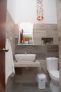 a bathroom with a sink and a toilet and a mirror at Filoxenia Studios in Vromolithos +59 photos