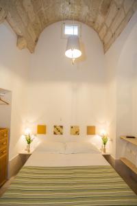 a bedroom with a large bed in a white wall at Le Casette Di Brando E Nico in Tricase