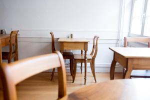 una sala da pranzo con tavoli e sedie in legno di Bett am Weiher a Wil