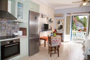 a kitchen with a stainless steel refrigerator and a table at Filoxenia Studios in Vromolithos