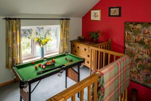 um quarto com uma mesa de bilhar e um berço em 1 Tan Yr Eglwys Barn Cottage em Pontardawe