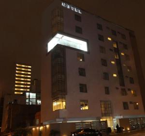 un edificio con un cartello di notte di Hotel Sunqu a Lima