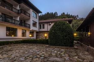a large bush sits in front of a building at Guesthouse Hitar Petar in Gabrovo