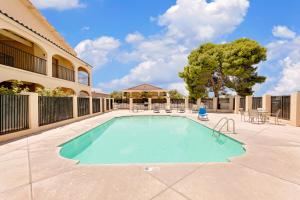 a swimming pool in the middle of a courtyard with a building at Silver Queen Inn in Kingman