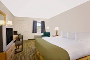 a hotel room with a large bed and a television at Silver Queen Inn in Kingman