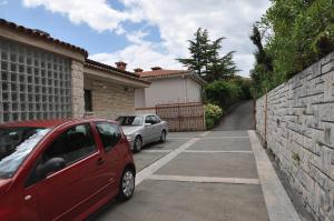 um carro vermelho estacionado num parque de estacionamento ao lado de um edifício em Apartments Vila Toni em Portorož