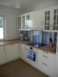 a kitchen with white cabinets and a blue towel at SEASIDE APARTMENTS - SUNNY BLUE in Eckernförde