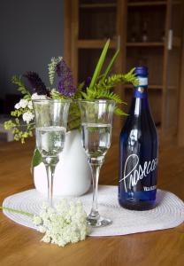 una botella de coca y dos vasos en una mesa. en SEASIDE APARTMENTS - SUNNY BLUE, en Eckernförde