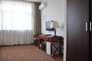 a hotel room with a television and a desk with a television at King Parkview Hotel in Beijing