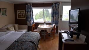 a bedroom with a bed and a table and a window at Above the Inlet in Sechelt