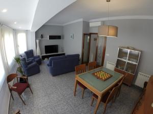 a living room with a table and a blue couch at LG Big Flat Barcelona in Badalona