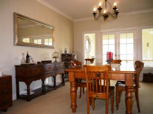 een eetkamer met een houten tafel en een spiegel bij Country Lodge Kinloch in Taupo