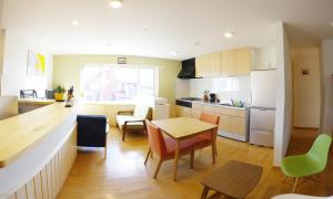 a kitchen with a table and chairs and a dining room at Niseko Guesthouse Nalu. in Niseko