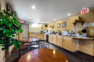 a kitchen with tables and chairs in a restaurant at Rodeway Inn Gunnison in Gunnison