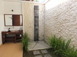 a bathroom with a shower in a stone wall at The Amrita - Salt Farm Villas in Tejakula +174 photos