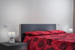 een slaapkamer met een rood bed met een zwart hoofdeinde en rode lakens bij Residenza Intra Lago Maggiore in Verbania