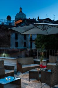 a patio with chairs and a table and an umbrella at Residenza Intra Lago Maggiore in Verbania