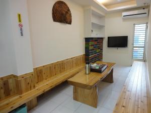 a court room with a wooden bench and a tv at Baisha Bay B&B in Xiaoliuqiu