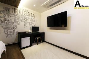 A2 Hotel Desingers في Yesan: غرفة بها جدار مع تلفزيون ومكتب